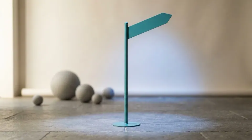 A navy conference stage spotlight falling on a single teal signpost against a warm off-white backdrop